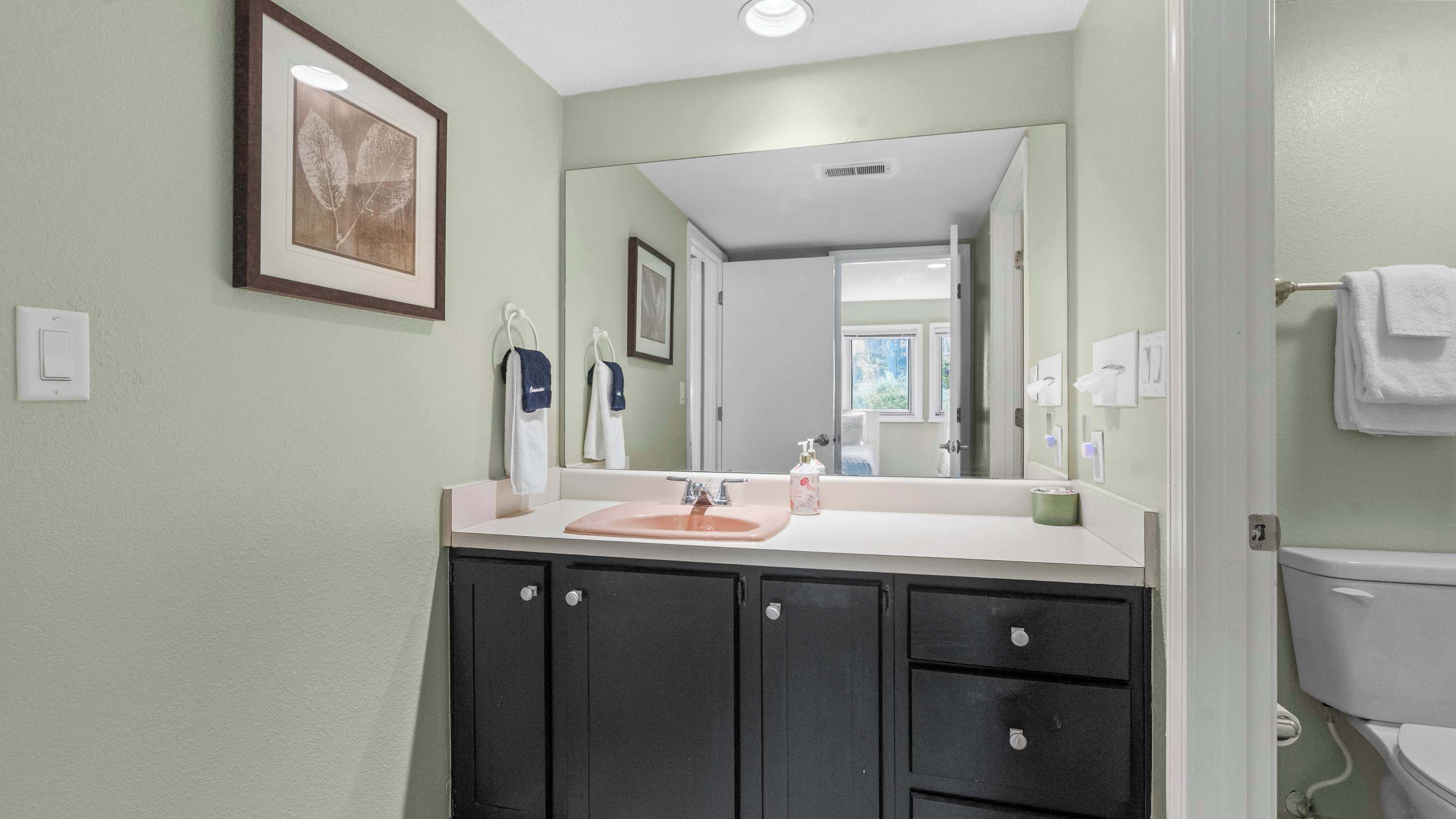 A bathroom with a sink, mirror, and toilet.