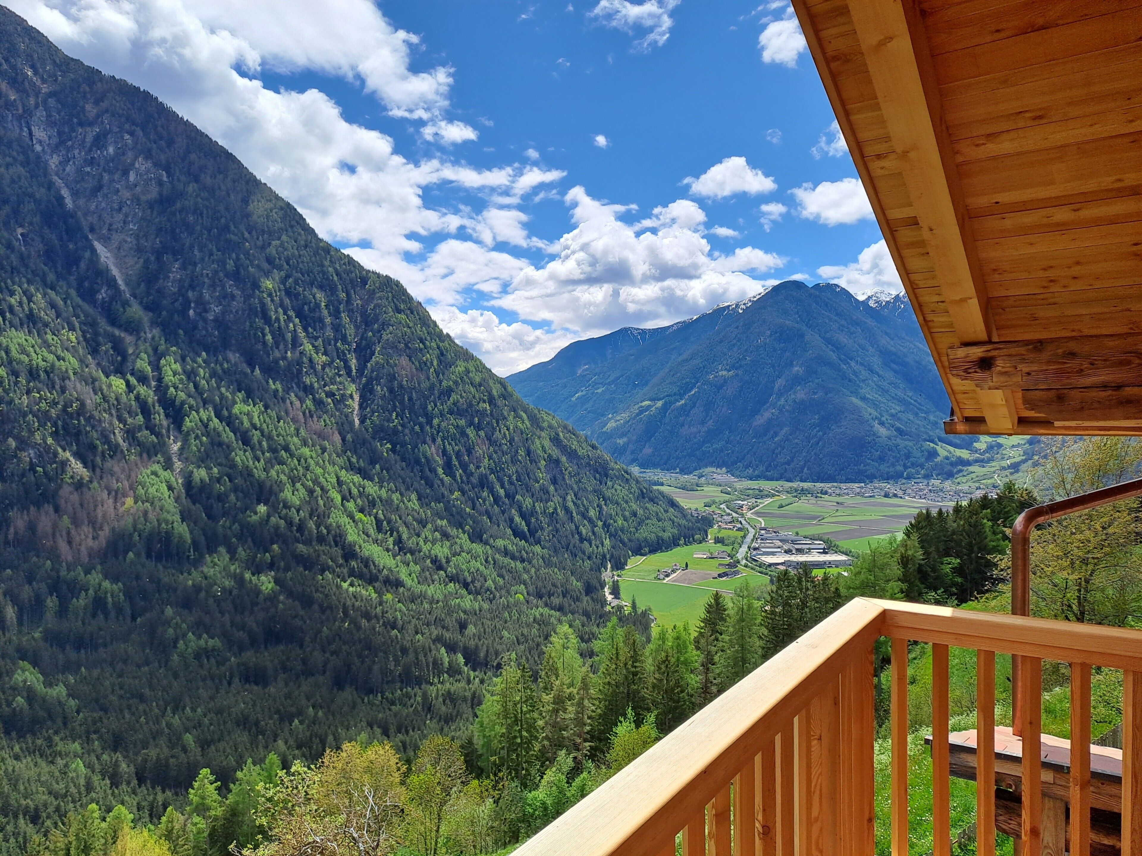 Un paysage de montagne avec une balustrade en bois sur un balcon.