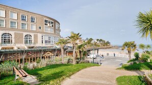 Ein Gebäude mit mehreren Fenstern und einer überdachten Außenfläche mit Holzkonstruktion.