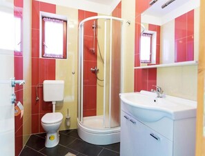 A bathroom with a toilet, a shower, and a sink. - Pool View Apartment With Balcony in Obrovac (Obrovac)