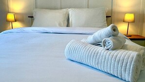 Een hotelkamer met een groot bed, twee kussens en twee bedlampjes.