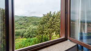 A window with a view of a green landscape, including trees and hills. - Vacation Home 'Villa Marisol Agrustos' with Private Terrace, Wi-Fi and Air Conditioning (Budoni)