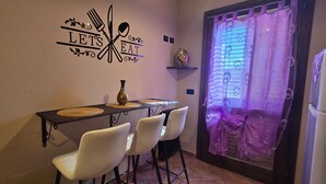 Un comedor con un cartel en la pared, una mesa con individuales y dos sillas.