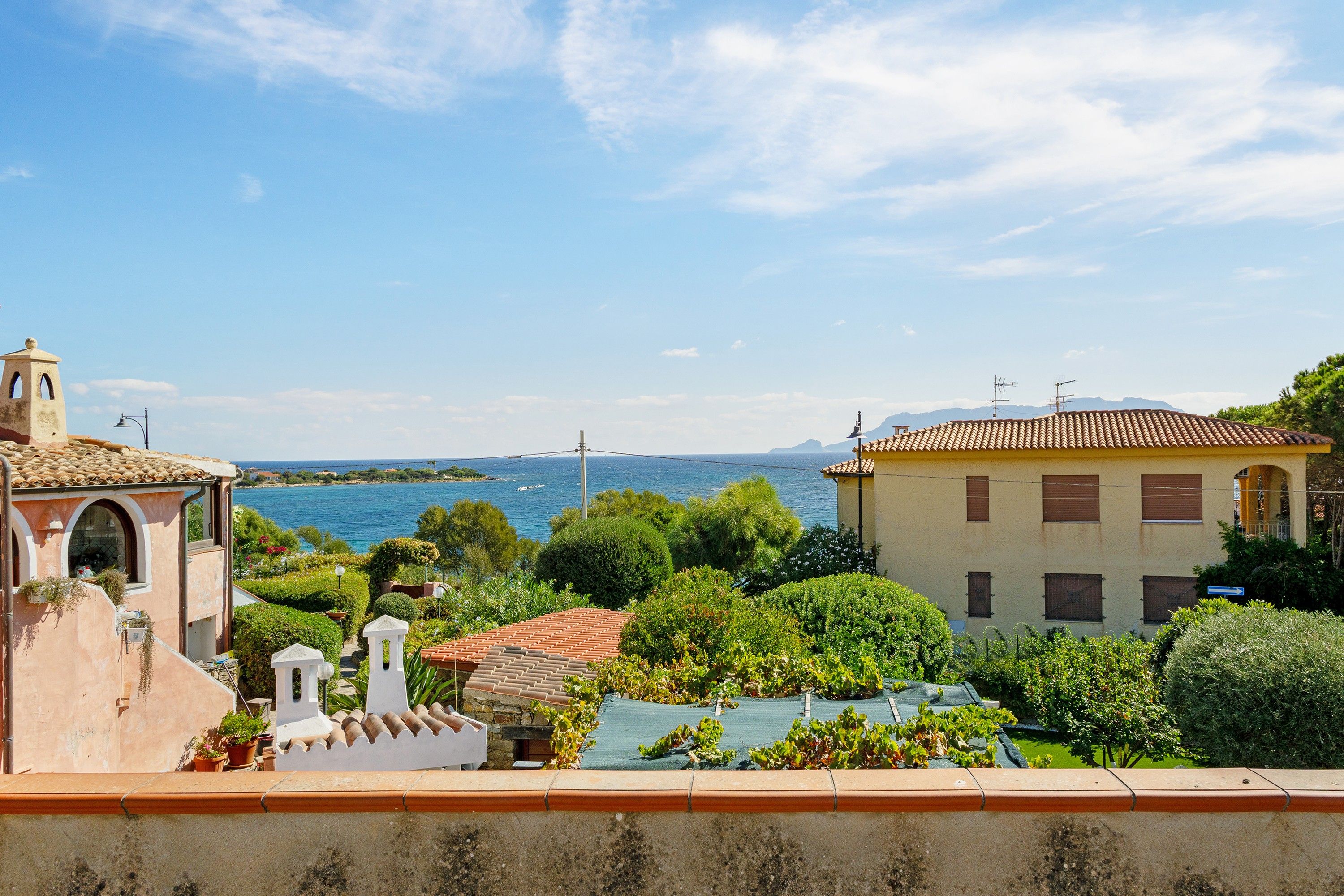 A coastal property with a view of the sea, a swimming pool, and a garden.