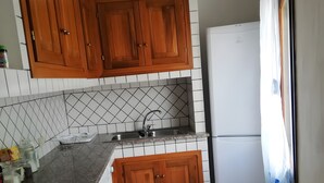 Eine Küche mit Holzausstattung, einem Spülbecken, einem Herd und einem Kühlschrank.