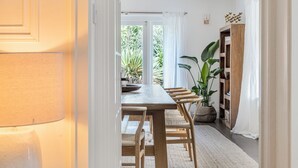 En matplats med ett träbord och stolar, en stor växt och ett träskåp.