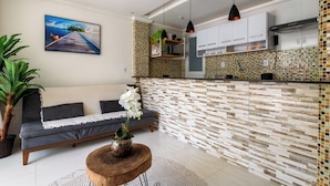A modern kitchen with a tiled backsplash, wooden cabinets, and pendant lighting. - ApartDeck Fantasy Island (Rio de Janeiro)