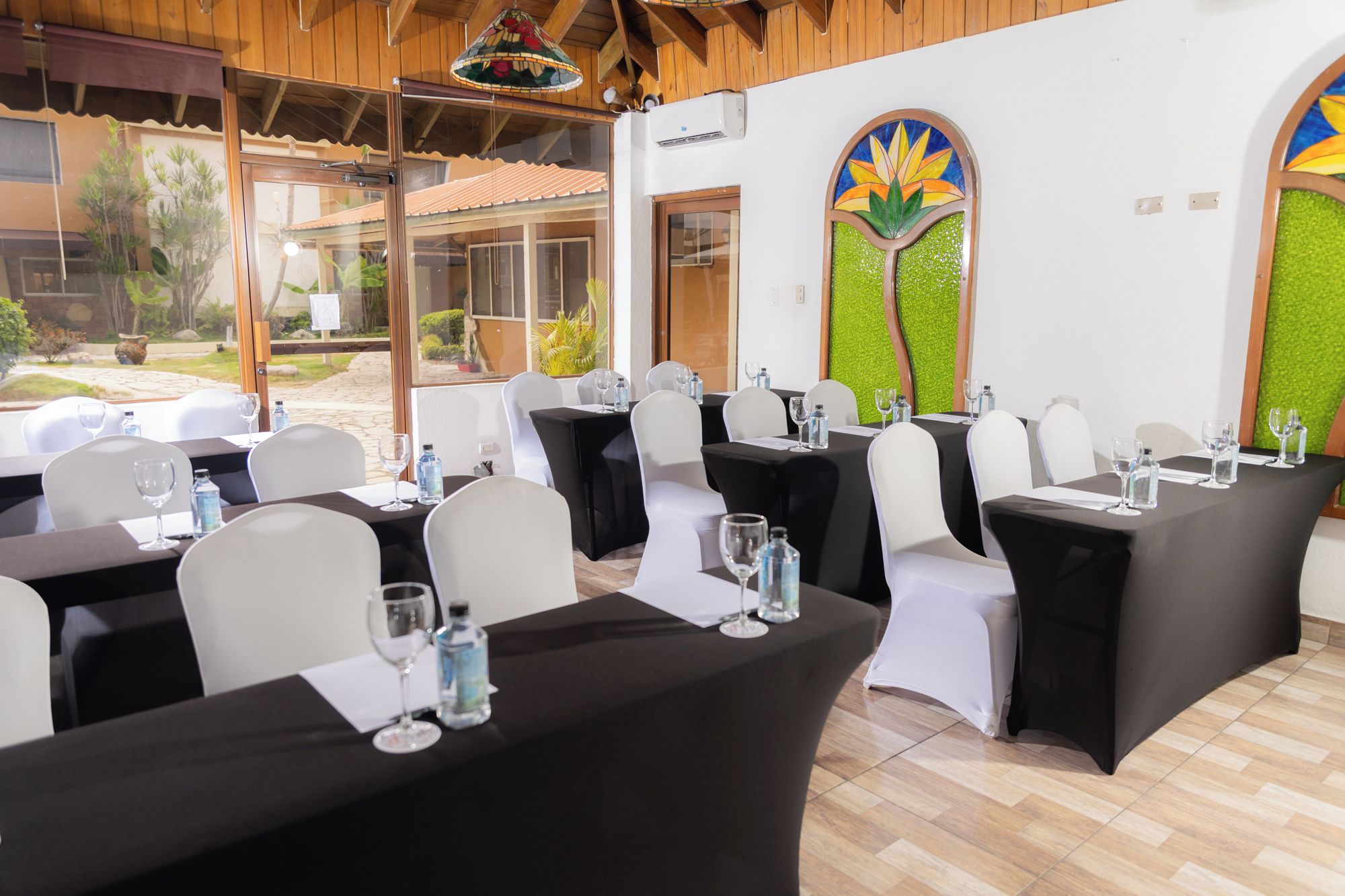 A restaurant with tables set for dining, featuring a view of the outdoors.