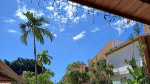 A courtyard with palm trees, a pool, and buildings with a modern architectural style.