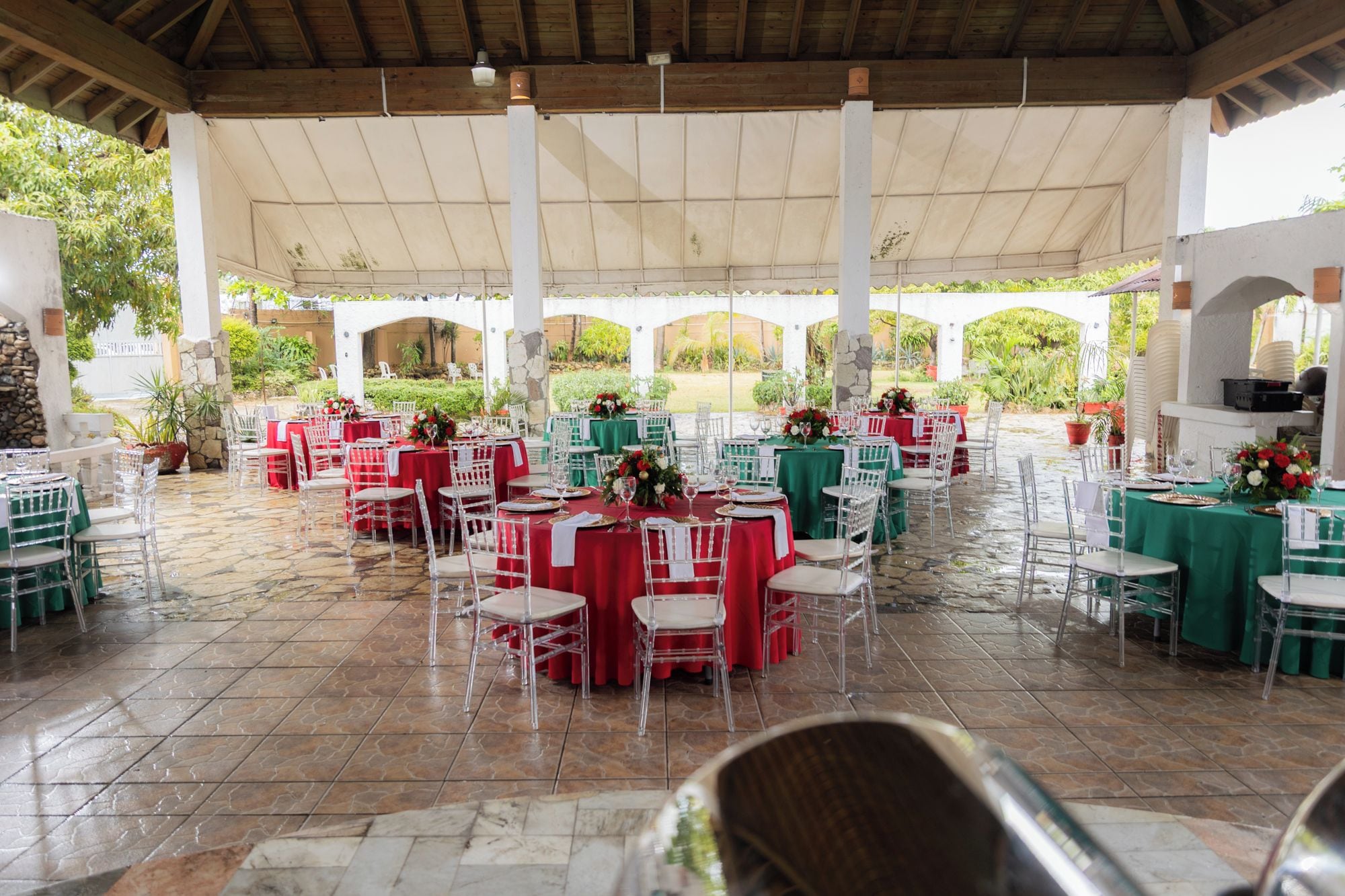 Un espace événementiel extérieur abrité, aménagé avec des tables et des chaises pour accueillir un groupe de personnes.