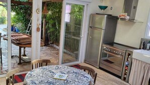 Una cucina con frigorifero in acciaio inossidabile, forno integrato e pensile porta pentole.