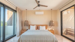 A modern bedroom with a large bed, a ceiling fan, and a view through a sliding glass door. - •|AMARU Penthouse | Private Rooftop & Quiet Living (Tulum)