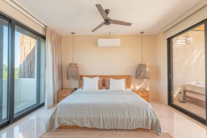A modern bedroom with a large bed, a ceiling fan, and a view through a sliding glass door. - •|AMARU Penthouse | Private Rooftop & Quiet Living (Tulum)