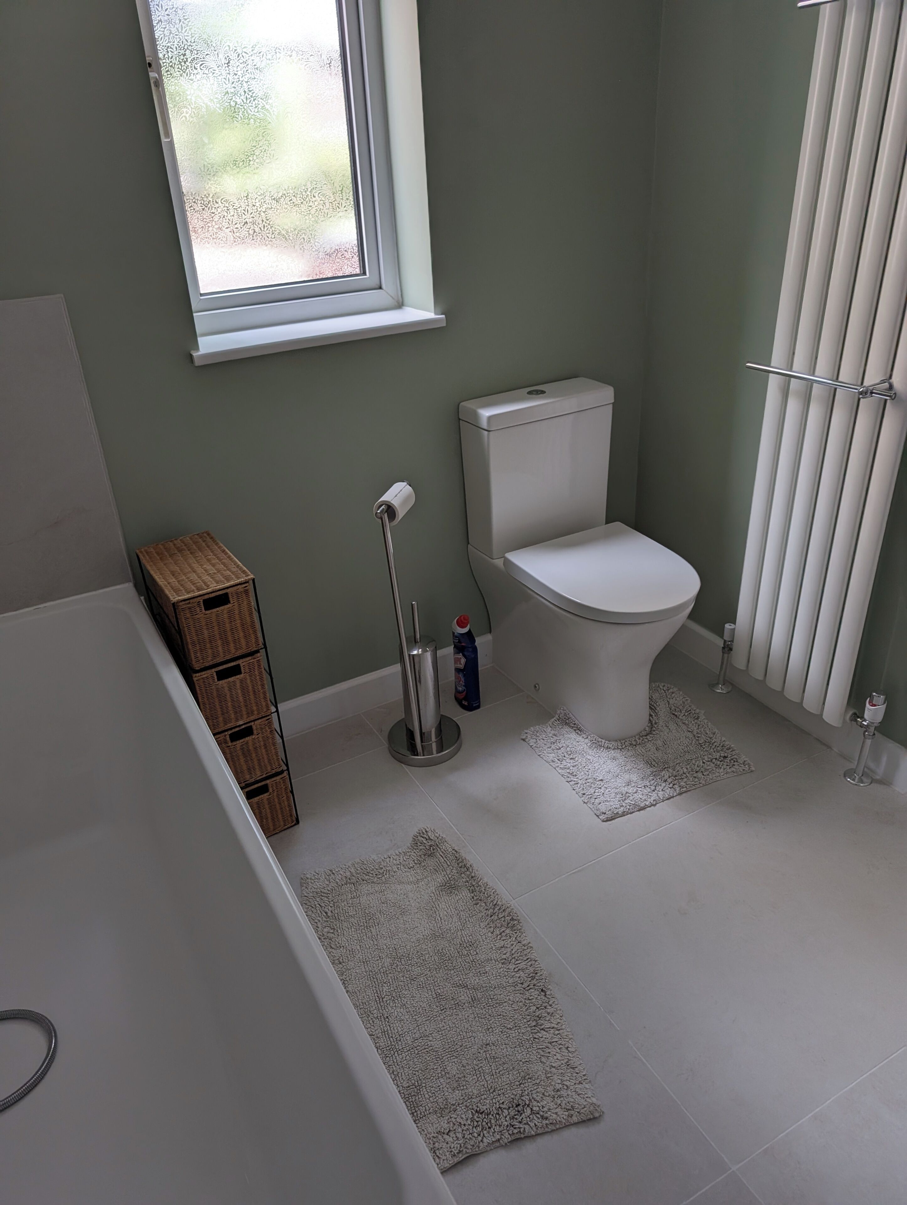 Une salle de bain comprenant des toilettes, un bidet, une fenêtre et une baignoire.