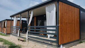 En modern, enplansbyggnad med ett takförsett utomhusområde, träpanel och ett betonggolv.