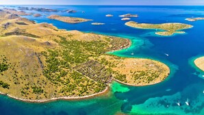 Ett flygbildsbild av ett kustområde med flera små öar och ett stort fastland med tät vegetation.
