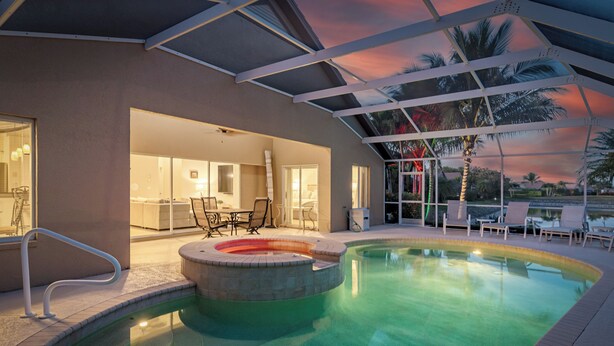 An indoor swimming pool with a hot tub, lounge chairs, and a covered patio area. - Lely Resort Single-Family Home Monthly Min Stay (Naples)