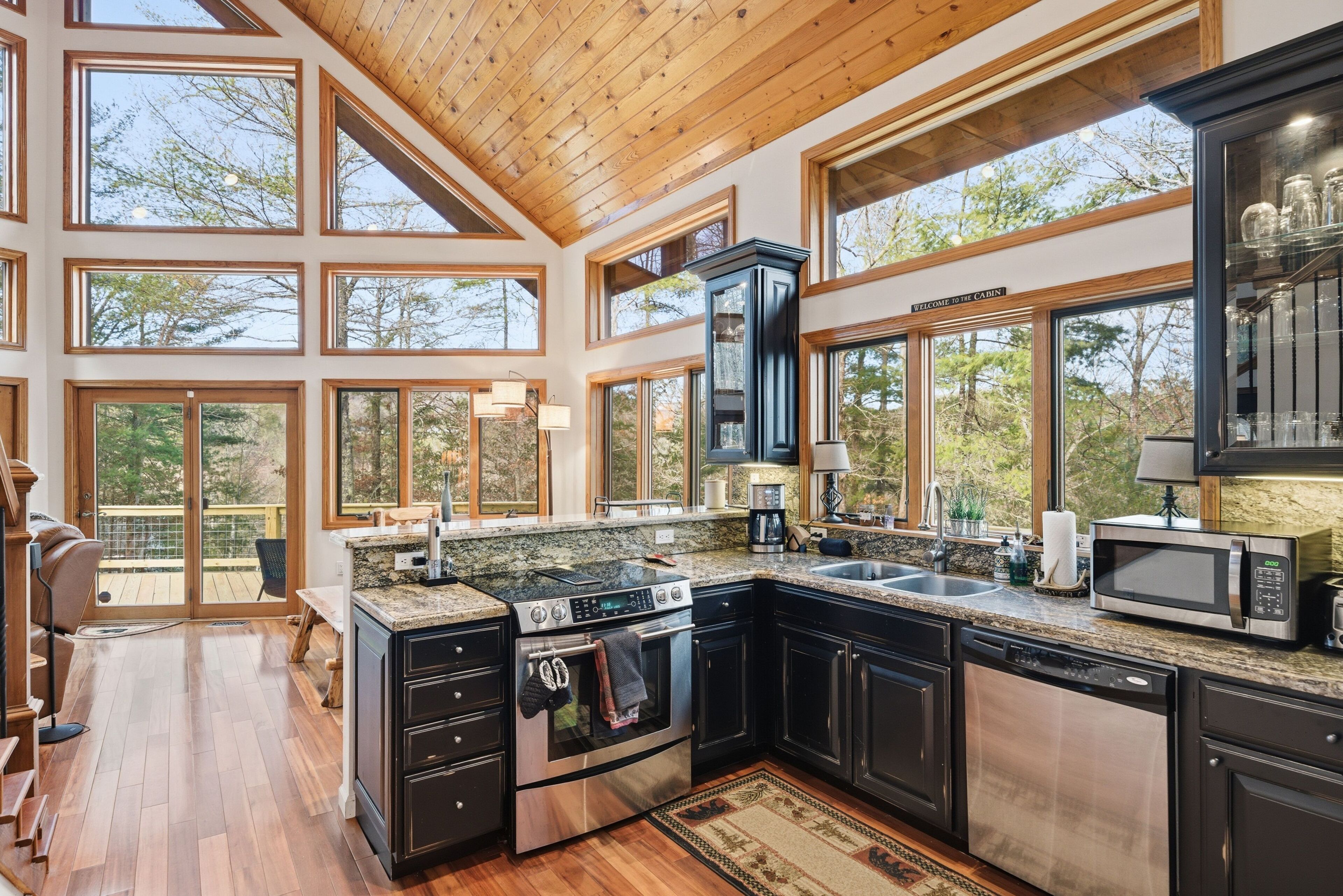 A spacious kitchen with large windows, a built-in oven, and a dishwasher.