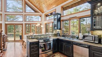 A spacious kitchen with large windows, a built-in oven, and a dishwasher.