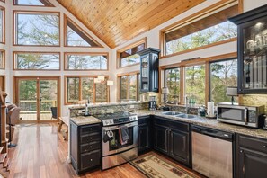 A spacious kitchen with large windows, a built-in oven, and a dishwasher. - Pet-Friendly Home Near Vogel State Park (Blairsville)