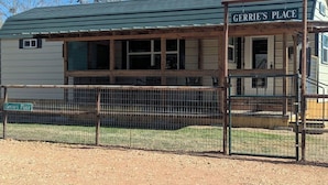 A building named 'Gerrie's Place' with a covered porch and a fenced area in front.