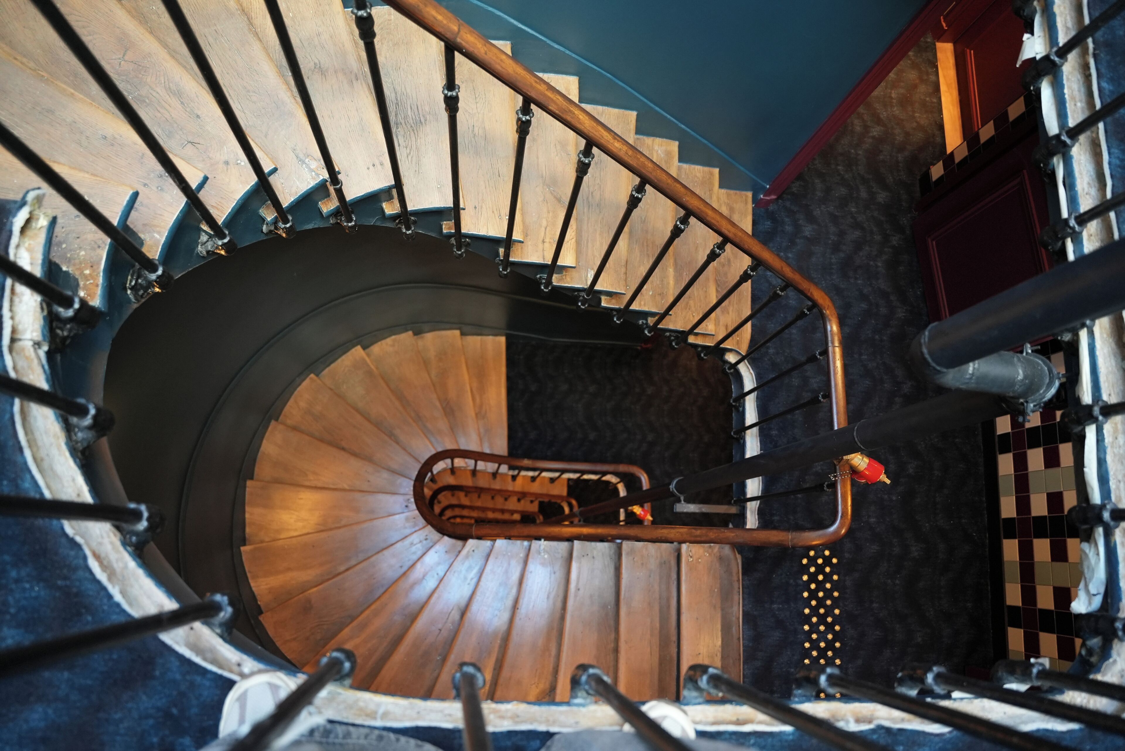 A spiral staircase with a wooden finish and metal railings.