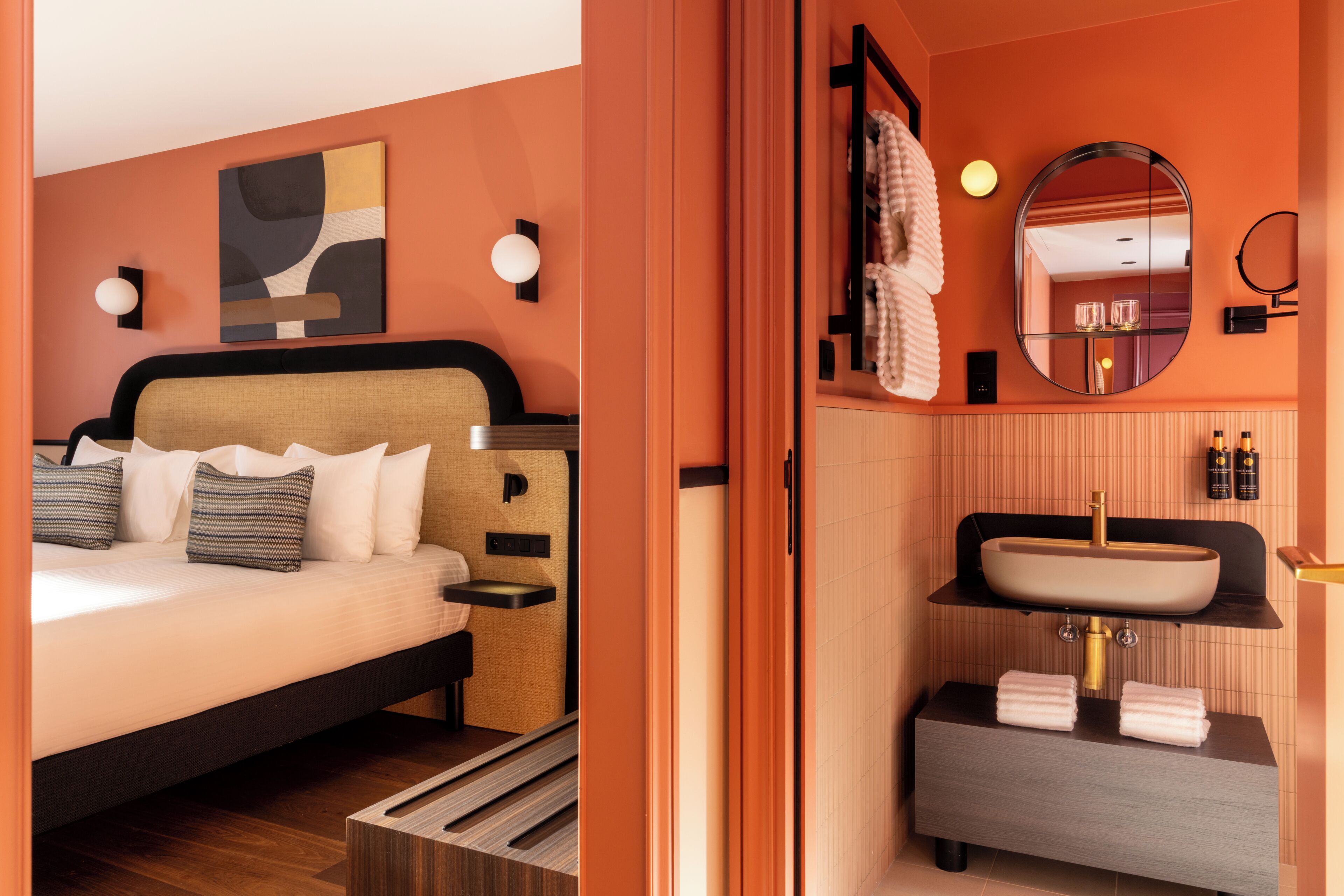 A modern bedroom with a bed, bedside table, and a wall-mounted abstract painting.