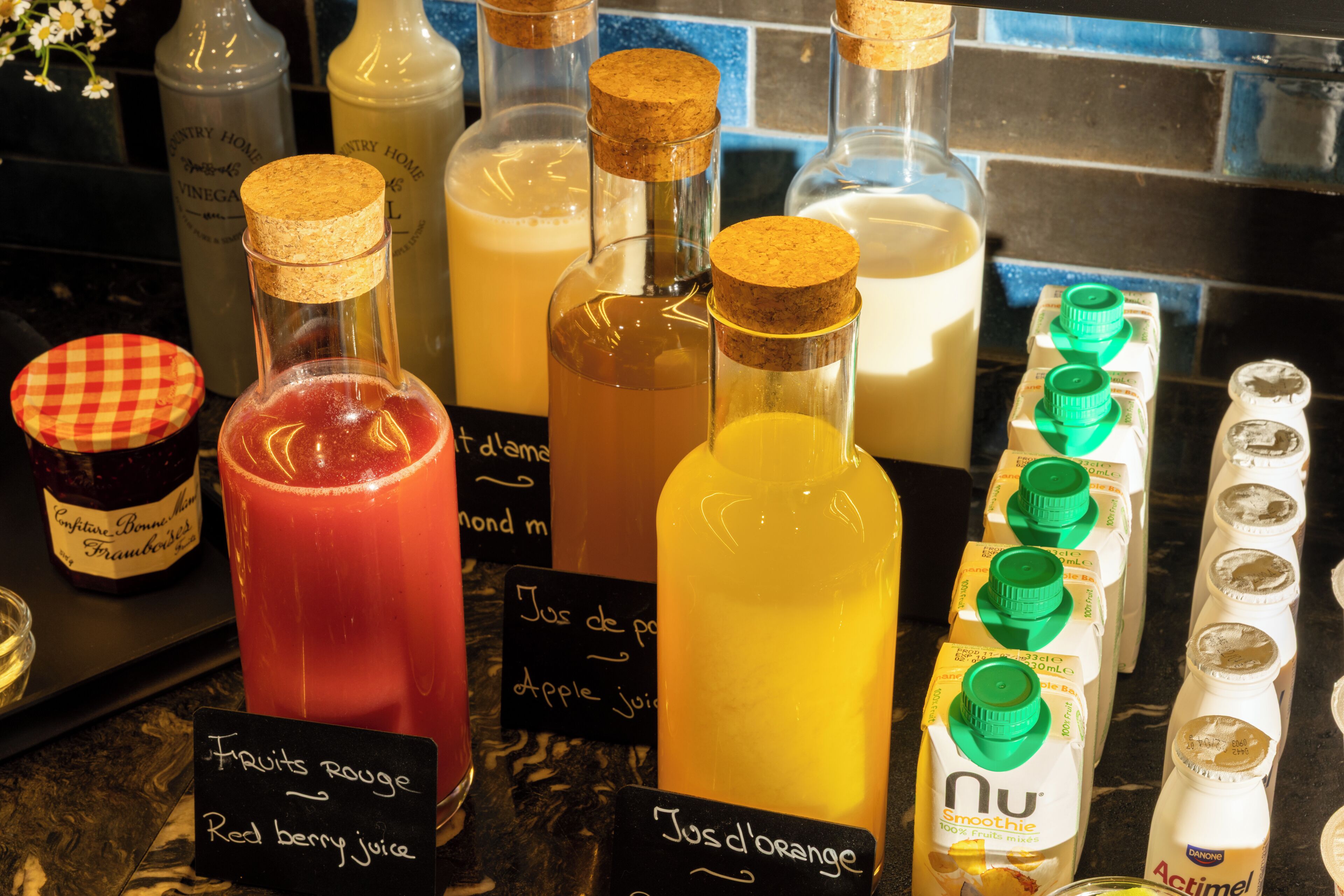 A variety of beverages, including juices and smoothies, displayed on a counter with labels.