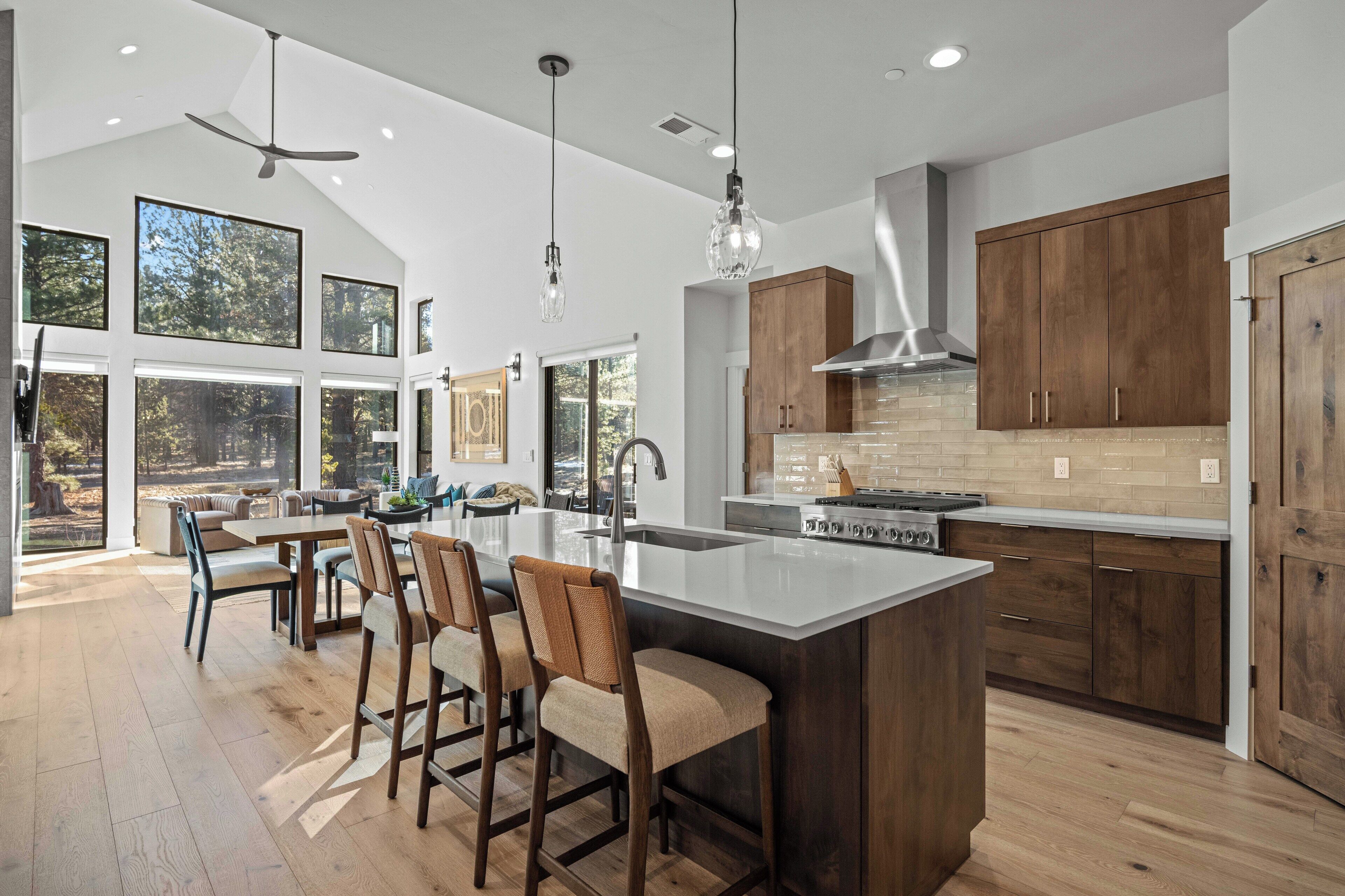 A spacious kitchen with a large island, wooden cabinets, and a view of the outdoors.