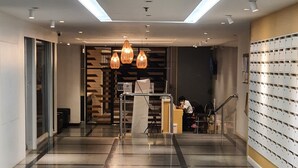Eine moderne Hotelhalle mit poliertem Fliesenboden, einem Empfangstresen und einer Schrankwand.