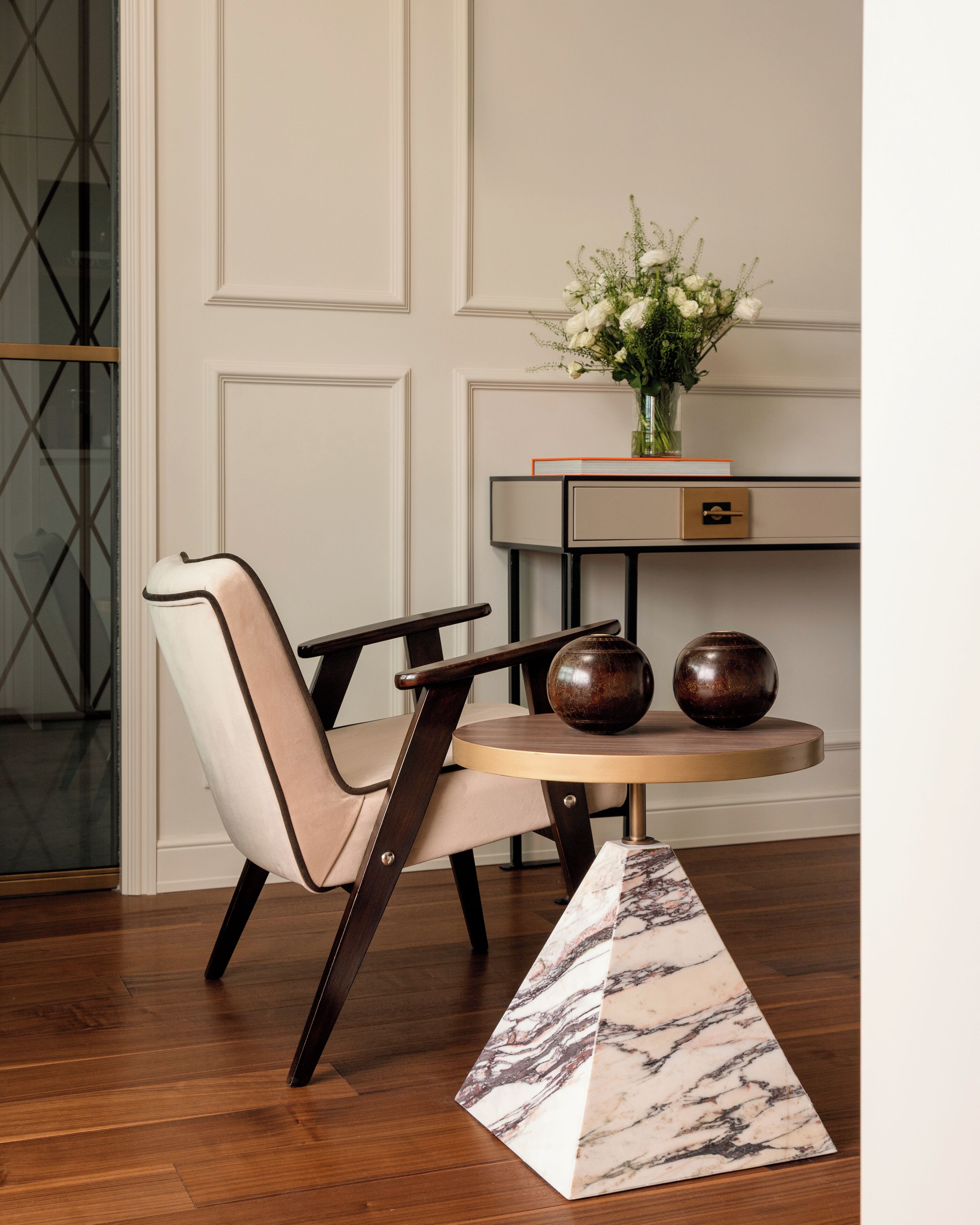 Un coin repas comprenant une chaise, une table et un vase de fleurs.