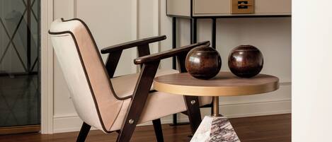 Un coin repas comprenant une chaise, une table et un vase de fleurs.