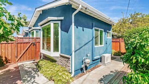 A two-story house with a blue exterior, a front porch, and a wooden fence. - 1bd/1ba Sunnyvale Suite w/ Private Fenced Patio (Sunnyvale)