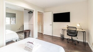 Ein Hotelzimmer mit einem Bett, einem Schreibtisch mit Stuhl, einem Fernseher und einem Fenster.