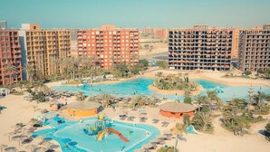 A resort with multiple swimming pools, palm trees, and beach areas. - Porto Golf Marina Apartments (El Alamein)