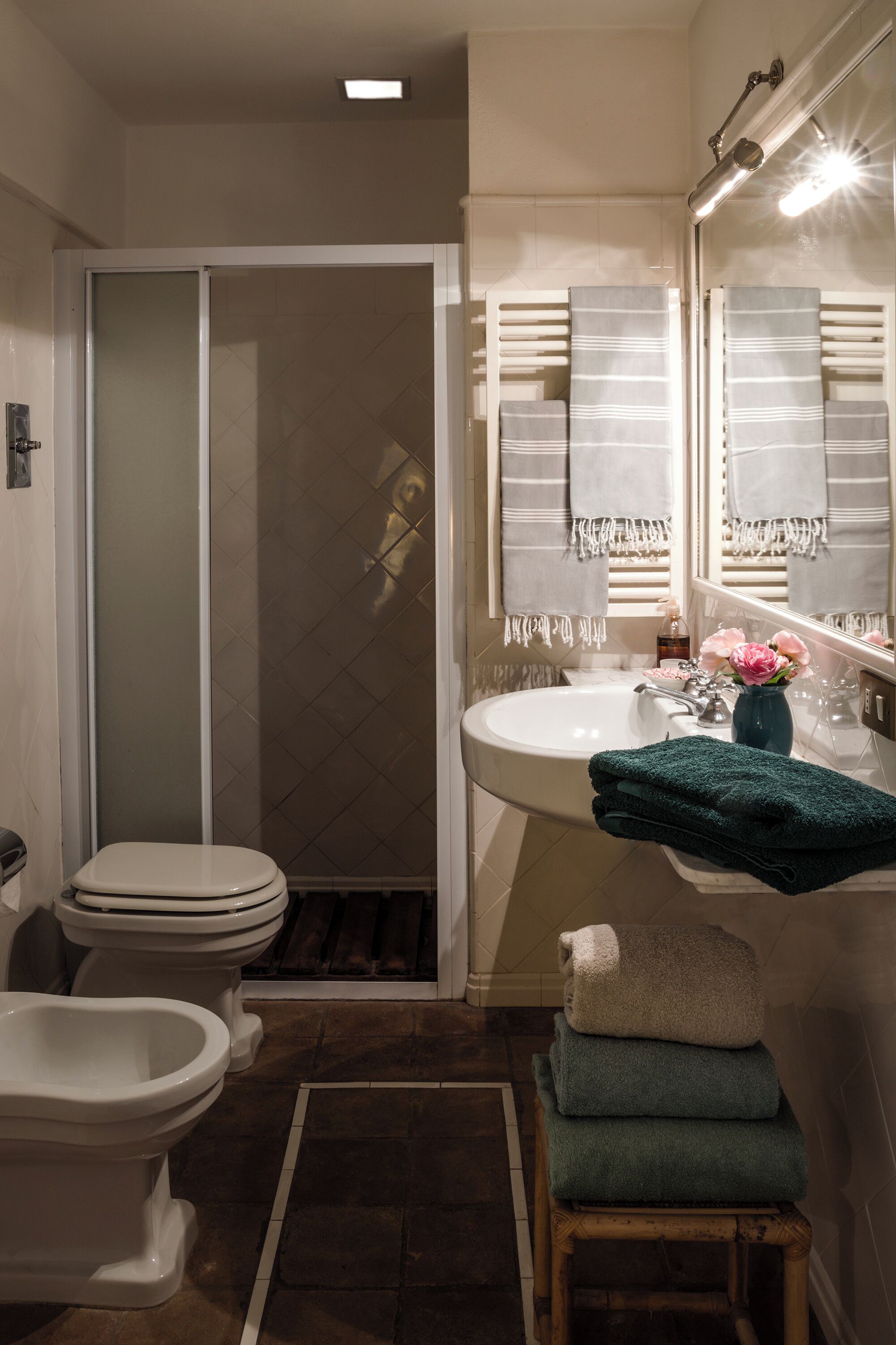 A bathroom with a toilet, bidet, and shower.