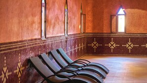 Ein Zimmer mit gemusterten Wänden, gefliestem Boden und einer Reihe schwarzer Lounge-Stühle.