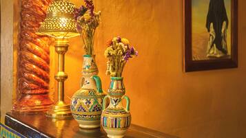 Tres jarrones decorativos con arreglos florales sobre una estantería.