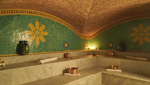 Ein Badezimmer mit grüner Mosaikwand, einem мраморном Waschbecken und einer Ziegeldecke.