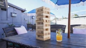 Een stapel houten blokken op een tafel, met een glas sinaasappelsap en een blauwe paraplu.