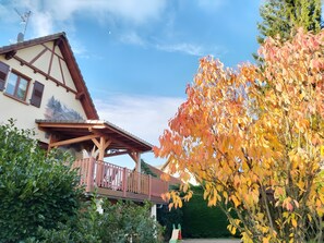 A traditional chalet with a balcony, surrounded by autumn foliage. - Guest Rooms - Pampas Room (+ Elie Room) (Geiswiller)