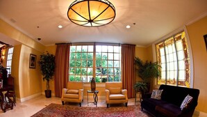 A spacious living room with a large window, two armchairs, a sofa, a patterned rug, and a chandelier. - Spacious Pet-Friendly Riverside Suite 3 Units w/ Grill & Bar, Pool & Hot Tub (Laredo)