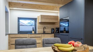 Eine moderne Küche mit Holzausstattung, einem eingebauten Ofen und einem Fenster mit Blick ins Freie.