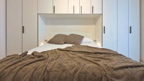 A bedroom with a bed, a headboard, and a wardrobe. - Casa Elena Cozy Stay Steps From Metro Station (Milan)