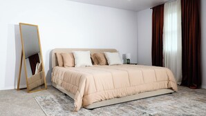 Une chambre à coucher avec un lit, un miroir et une table de chevet.