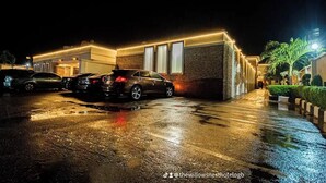 Hotellissa on pysäköintialue ja modernisti suunniteltu rakennus, jossa on tiiliverhous ja suuret ikkunat.