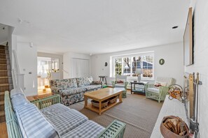 Ein geräumiges Wohnzimmer mit einer Sofagarnitur, einem Couchtisch und einem Kamin.