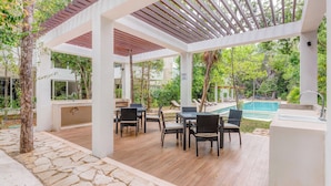 Un espace extérieur abrité comprenant une piscine, un revêtement de sol en pierre et du mobilier d’extérieur.