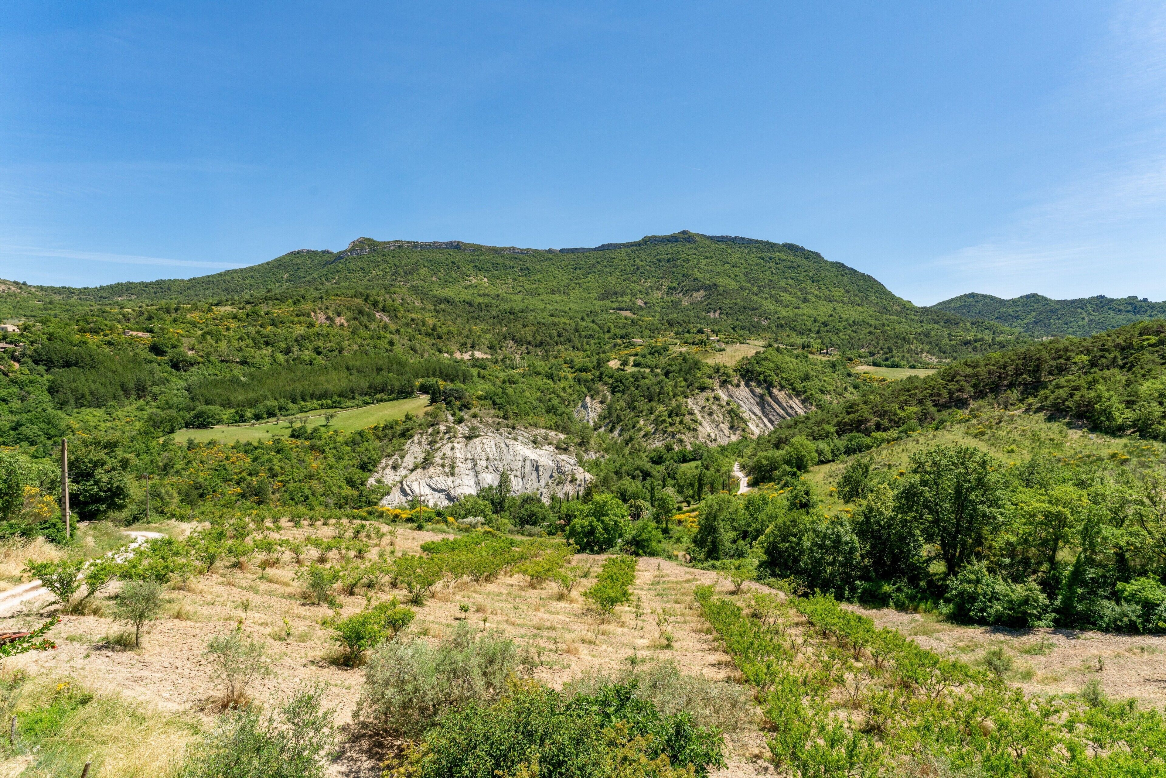 A mountainous landscape with green vegetation and rocky outcrops.