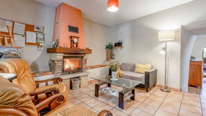 A living room with a fireplace, leather furniture, a glass coffee table, and a floor lamp. - Le frêne – La Ferme des Aygues, Drôme Provençale (Montaulieu)